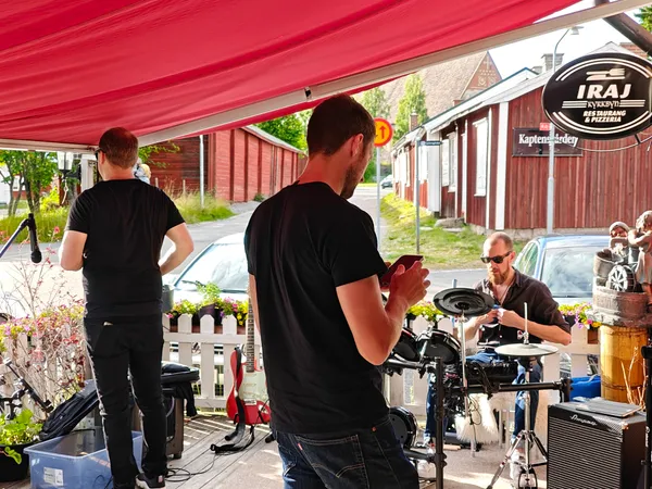 Bandet riggar inför spelning under markisen vid Iraj i kyrkbyn